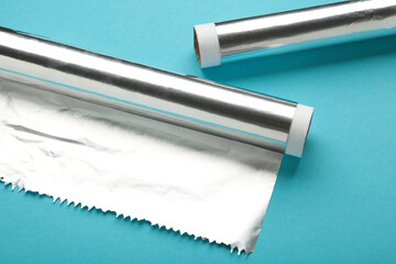Rolls of aluminum foil on blue background.