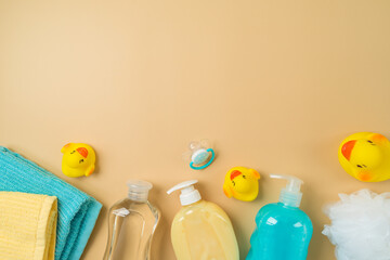 Baby health care products on modern background. Infant shampoo, oil, soap, duck toys and towel. Top...