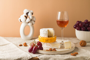 Still life with cheese, grapes, nuts and wine glass on table