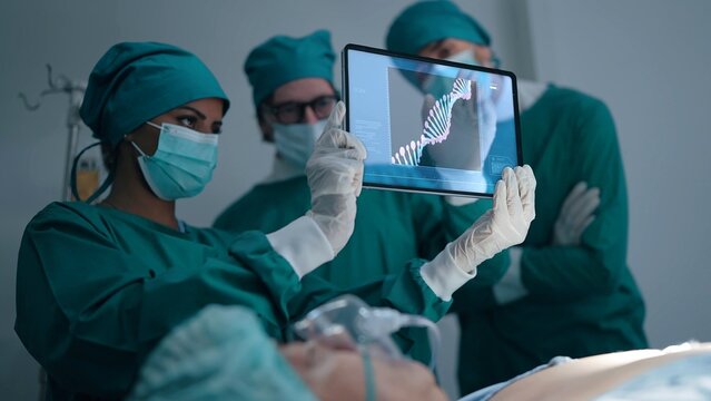 Professional medical team talking and discuss x-ray of patient with Rotating DNA chain - deoxyribonucleic acid at radiology department in hospital