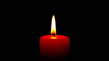 Single red candle flame lights, isolated on a black background