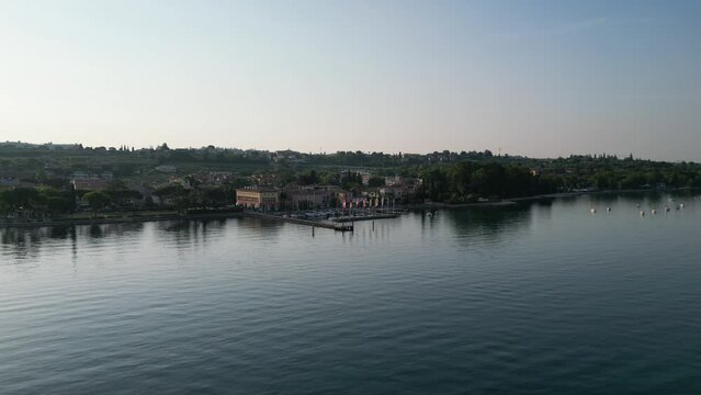 Flying Over Lago di Garda With Coastal Town And Hotels In Cisano, Province of Verona, Italy. - aerial