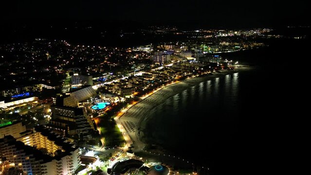 Sa Coma Beach With Sparkling Lights At Night In Balearic Islands, Spain. aerial hyperlapse