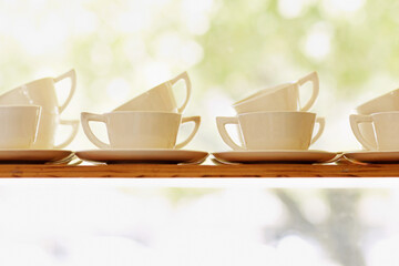 Collection, tea or coffee mug closeup and porcelain cup with plate on window shelf with background mockup. White, ceramic and breakfast catering service set for party and cafe, hotel or restaurant