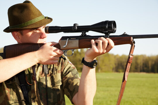 Hunting, gun scope and man hunter on Africa safari in grass for shooting animals on holiday. Weapon, sniper and male person aim for wild game in nature with mockup and sport for target shot in sun