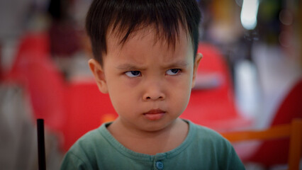 Angry little asian boy showing frustration and disagreement. Mad kid got upset and sad and he has a...