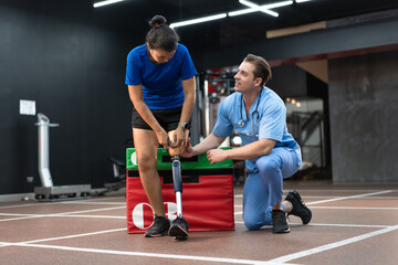 Caucasian assisted male physiotherapist take care Asia woman with prosthetic leg