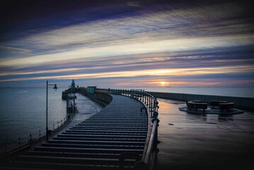 Folkestone's Harbour Arm and Lighthouse at dawn.