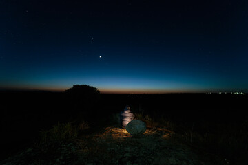 Night landscape with sitting person.