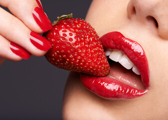 Beauty, makeup and woman with a strawberry in a studio with red nails and lipstick cosmetics....