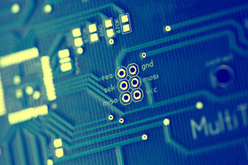 Macro shot of the back side of a circuit board. Close up of the blue circuit board