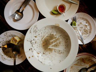Dishes are messed up after eating on the table.