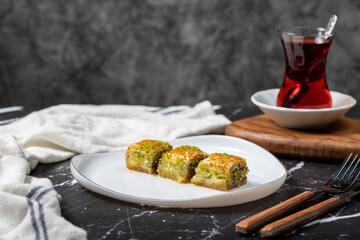 Baklava with pistachio on a dark background. Traditional Turkish baklava. Local name ankara sarmasi