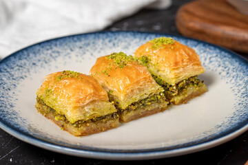 Baklava with pistachio on a dark background. Traditional Turkish baklava. Close up