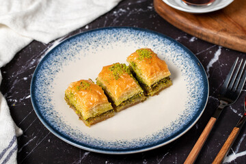 Baklava with pistachio on a dark background. Traditional Turkish baklava