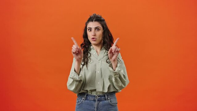 Charming young woman showing NO with her finger, looking at camera, expressing refusal and denial