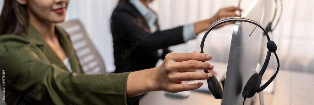 Aufkleber panorama focus hand holding headset on call center workspace desk with blur background of operator t
