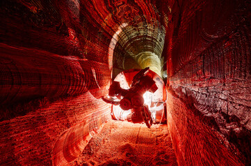 Illuminated mining drilling machine in salt quarry tunnel