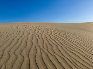 Sand dunes with different patterns even with light winds