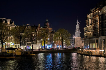Nightshot of Buildings along the Amstel River in Amsterdam, Holland, with Munttoren
