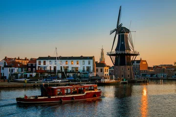Fotobehang The Binnen Spaarne Canal Running through Haarlem, the Netherlands, with the Famous Windmill De Adriaan, in the Afternoon Sun © Rolf