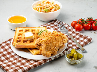 Deep-fried chicken and waffles poured with syrup.