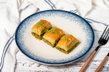 Pistachio baklava on wood background. Traditional Turkish baklava with pistachio. Sherbet dessert