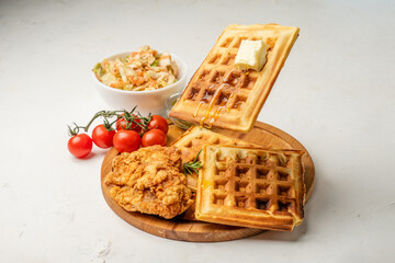 Waffles with syrup and butter and fried chicken pieces, food concept. light background. Food levitation. Cooking food concept.