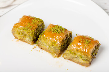 Baklava with pistachio on a wood background. Traditional Turkish baklava. Local name ankara sarmasi. Close up