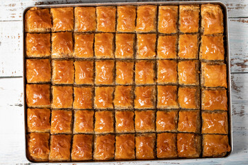 Pistachio baklava on wood floor. Tray of baklava. Traditional Turkish cuisine delicacies. sherbet sweets. Top view