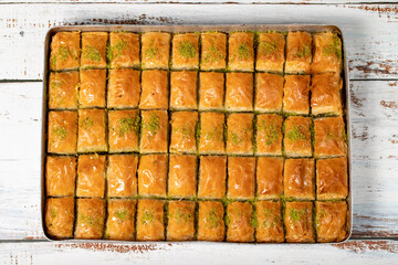 Pistachio baklava on wood floor. Tray of baklava. Traditional Turkish cuisine delicacies. sherbet sweets. Top view
