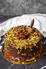 Pistachio and chocolate cream cake. Birthday or celebration cake on dark background. Close up