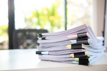 Businesswoman hands working on stacks of paper documents to search and review documents piled on...