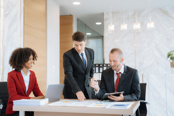Mature business leader consultant talking to team of diverse colleagues listening to white CEO. professional investor working new start up project. 
