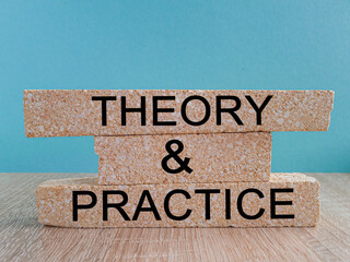 Theory and practice symbol. Brick blocks with words 'Theory and practice' on a beautiful blue background. Wooden table. Business, theory and practice concept. Copy space.
