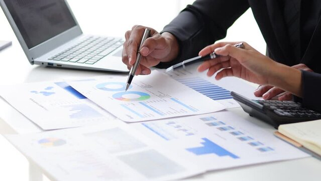 Meeting business people are analyzing business finance and investment charts and discussing the company's marketing growth strategy. Accounting and Financial Planning