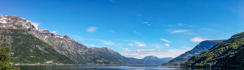 The wide panorama of the lake in Norway with the mountains in the background. 