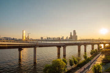 Sky Scraper in the city shining golden behind the legs of the river of the sunshine