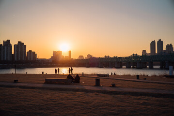The sunset scenery shows the silhouette of the SKY Scraper in the city and the silhouette of people looking at the sunset.