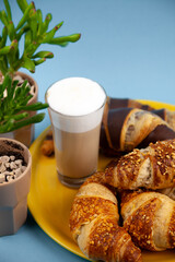 Chocolate croissants or croissant with nut crumbs on a plate. Delicious breakfast on the table. Tasty sweet baking dessert for coffee. Food background. Fresh buttery croissants rolls
