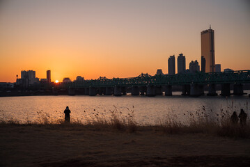 Sky Scraper in the city and the sunset scenery shows the silhouette of a person.