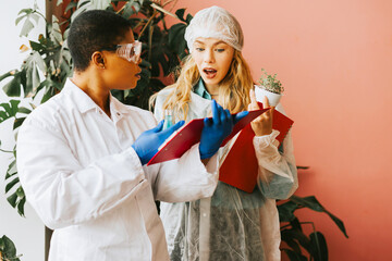 african american and caucasian woman student with conducts an experiment with beaker and liquid in protective glasses, studies viruses and bacteria, scientist doctor of biology with scientific project