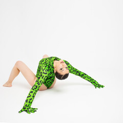 Stylish bright dancer in a bright green leopard print bodysuit, studio photo on a white background....