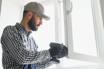 Fototapeta premium service man installing window with screwdriver