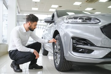 a man examines a car in a car dealership