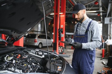 Fototapeta na wymiar Professional Mechanic is Working on a Car in a Car Service.