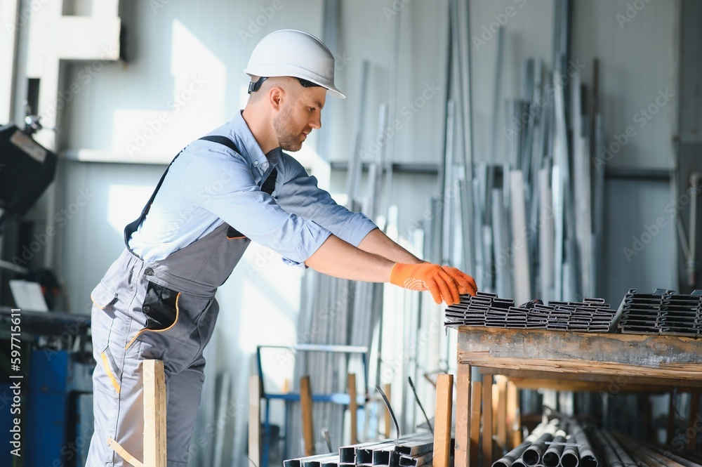 Wall mural male factory mechanics or engineer in safety uniforms are working on metal drilling machines in indu