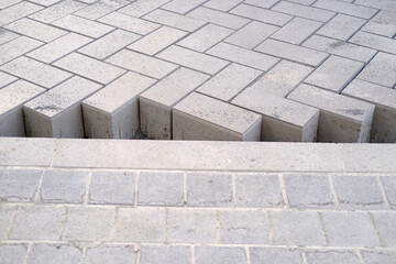 gray paving blocks on the ballast, side view, construction site of pavement modern granite...