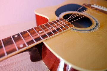 Fototapeta premium close-up wooden part of the instrument, changing strings on acoustic guitar, strings hanging freely, guitar tuning, replacing strings torn from energetic performance to play musical instruments