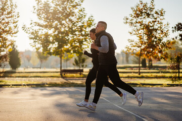 Two athletes, a couple, jogging together in the park